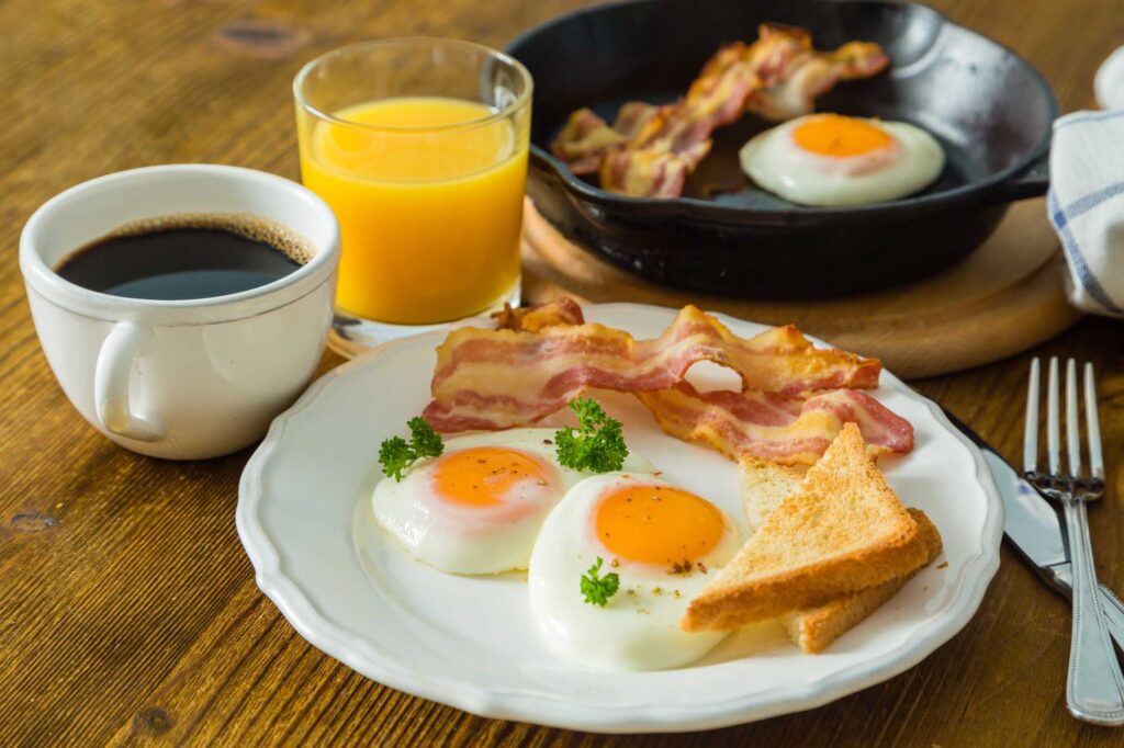 Classic American breakfast with sunny side up eggs, bacon, toast
