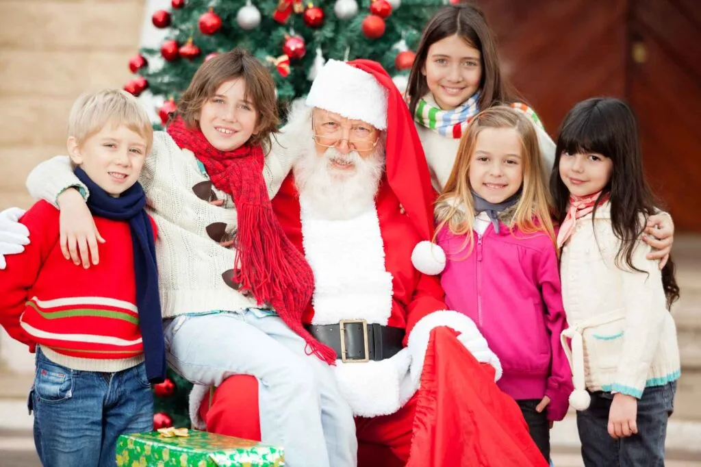 Smiling children posing for a picture with Santa