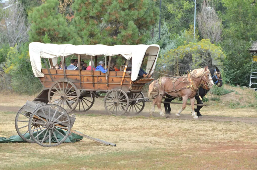 Tourists on a horse-drawn wagon at the Four Mile Historic Park in Denver