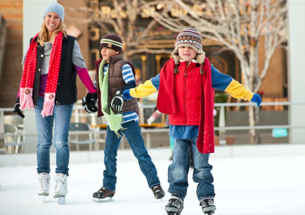 Mom and children ice skating outdoors
