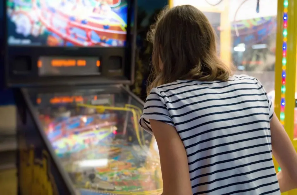 Girl playing on pinball machine