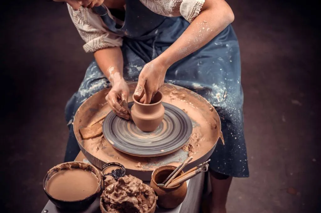 Woman making pot with clay
